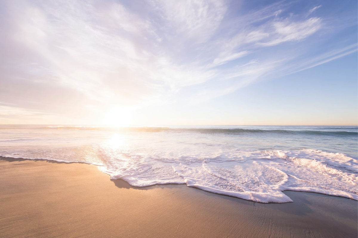 Sandstrand mit sich brechenden Wellen